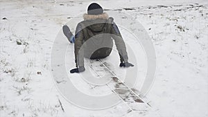 Young stylishly dressed man while walking in the Park in winter slipped and lost his balance