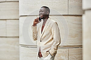 Young successful African American businessman with smartphone by ear