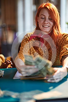 A young successful business woman in the office is counting the money with satisfaction. Employees, office, work