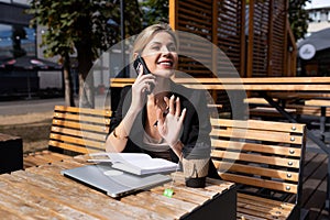 young successful business woman talking on the phone in a cafe