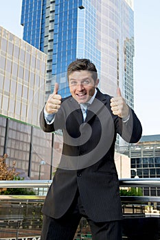 Young successful businessman happy and excited giving thumbs up okay sign