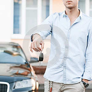 Young successful businessman offering a car key.