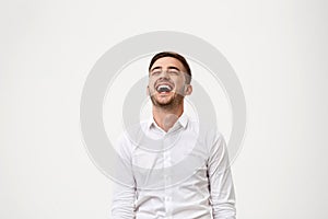 Young successful businessman smiling, laughing over white background.