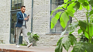 A young successful businessman is walking down the street. Man in a casual wear. Business, freelance and remote work.