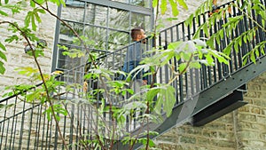 A young successful businessman is walking up the stairs. Man in a casual wear. Business, freelance and remote work.