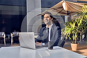 Young successful businessman working on a laptop while sitting in cafe during work break lunch,thoughtful entrepreneur connecting