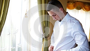 Young successful bussinessman dressing white shirt prepare for a bussiness meeting in a conference-salle of his hotel.