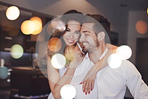 Young successful couple smiling, woman embrace man indoors, boke