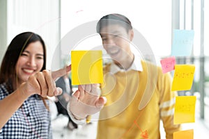 Young successful creative man and woman smile and brainstorm on project at office