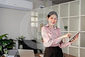 Young successful employee business woman asian use hold tablet computer at workplace desk at office. Achievement career