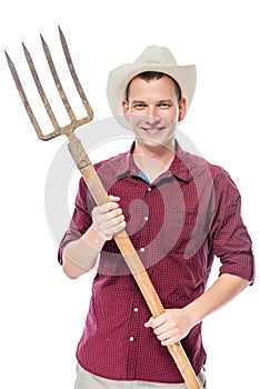 Young successful farmer in a red shirt with pitchforks