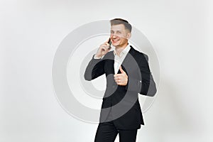 Young successful handsome rich business man in black suit on white background for advertising.