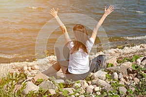 Young successful happy girl on the beach uses a laptop for work. Freelance work concept, Freelancer and blogger outside