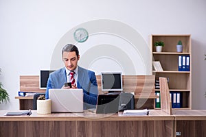 Young successful male employee working in the office