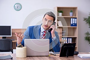 Young successful male employee working in the office