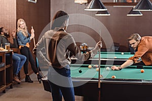 young successful multiethnic friends playing in pool