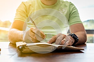A young successful person taking notes in a personal journal