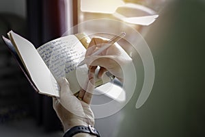 A young successful person taking notes in a personal journal