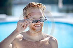 Young successful smiling bearded man in sunglasses