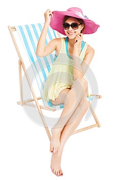 Young sunshine girl smiling and sitting on a beach chair