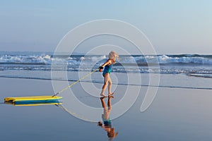 Young surfer girl with bodyboard has fun on sea beach