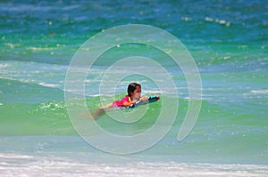 Young surfer girl riding waves.