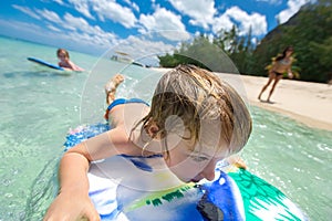 Young surfer, happy young boy in the ocean on surfboard.