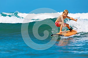 Young surfer learn to ride on surfboard on sea waves