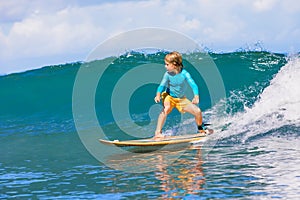 Young surfer learn to ride on surfboard on sea waves