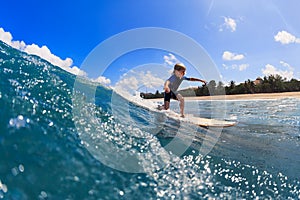 Young surfer learn to ride on surfboard on sea waves