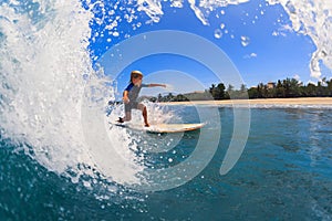 Young surfer learn to ride on surfboard on sea waves