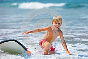 Young surfer learning ride, jump from surfboard, run to beach