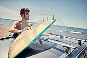 Surfer man at the beach getting ready for surfing