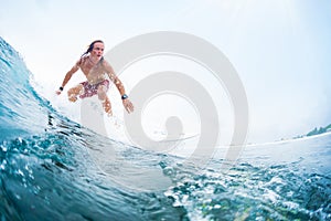 Young surfer rides an ocean tropical wave