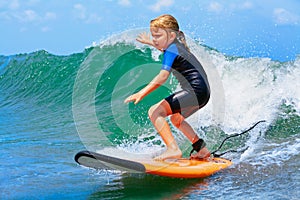 Young surfer rides on surfboard with fun on sea waves