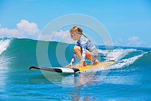 Young surfer rides on surfboard with fun on sea waves