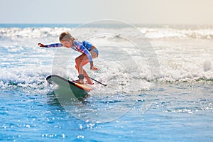 Young surfer rides on surfboard with fun on sea waves