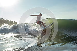 Young surfer with rides wave