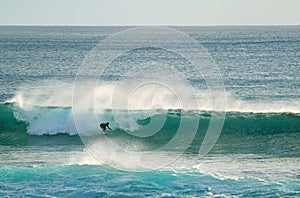 Young surfer riding on the breaking waves in Pacific Ocean at Hanga Roa, Easter Island, Chile photo