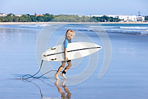 Young surfer run to ride on surfboard on sea waves