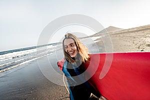 Young surfer with surfboard on the beach