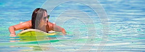 Young surfer woman surfing during beach vacation