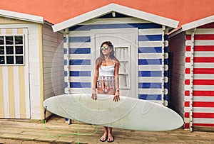 Young surfer woman with top and bikini holding surfboard