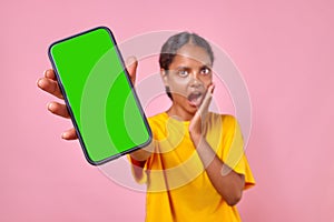 Young surprised Indian woman teenager with phone in hand opens mouth