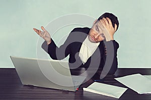 The young surprised man with his laptop computer, disappointment in business. problem at work. Crisis in business processes. unhap