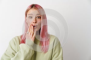 Young surprised woman covering her mouth and looking at camera