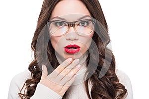 Young surprised woman with red lipstick wearing trendy glasses and looking at camera,