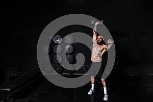 Young sweaty strong fit muscular man with big muscles doing push ups on the dumbbells in the gym hardcore cross workout training