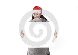 Young sweet Latin woman in Santa Christmas hat holding blank billboard as copy space