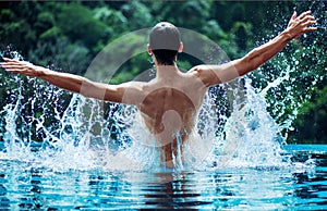 Young swimmer splashing water